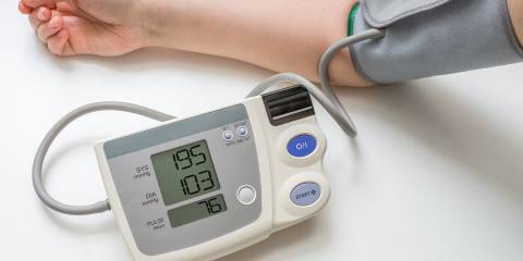 a woman using an at-home blood pressure sensor