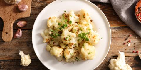 grilled cauliflower plated with a garnish