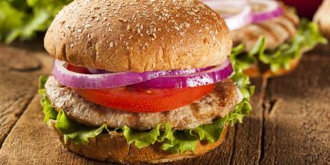 a homemade turkey-meat patty with lettuce, tomato, and onion