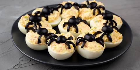 deviled eggs with black olive spiders