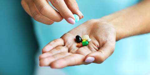 a woman with a few colorful vitamin capsules in her hand