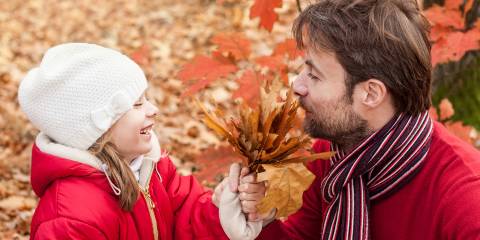 a man and his daughter enjoying autumn in the park