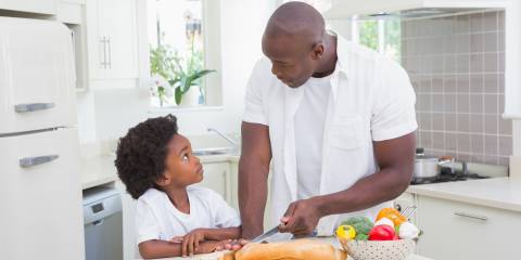 A father and son cooking with healthy foods in the kitchen.