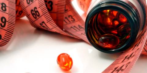 a measuring tape and a bottle of supplements