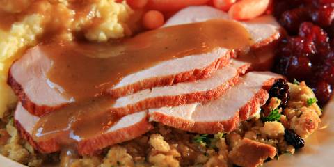 a plate of traditional turkey dinner with stuffing and gravy