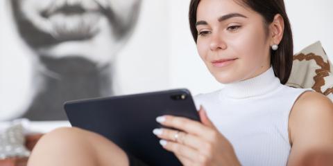 Woman with brunette hair and a white shirt communicating via email.