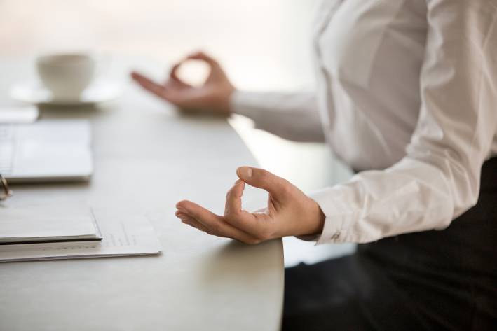 a businesswoman meditating at her desk