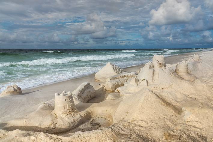 sand castles with waves approaching swiftly