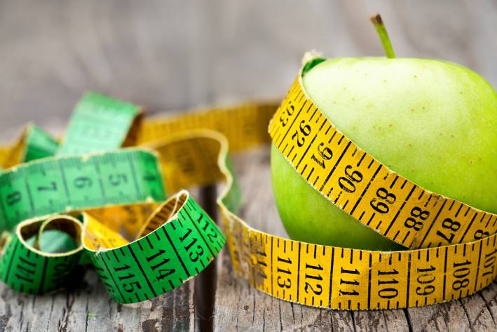 an apple with a measuring tape wrapped around it