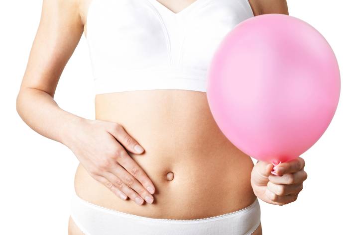 a woman feeling bloated, holding a balloon as a metaphor