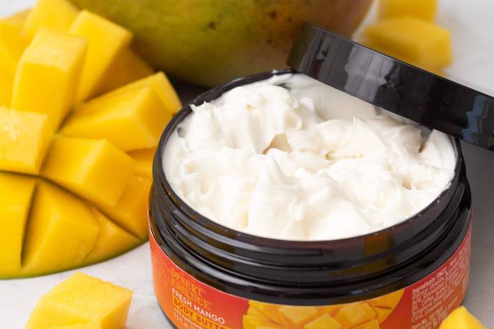 a small jar of lotion and some fresh mangoes