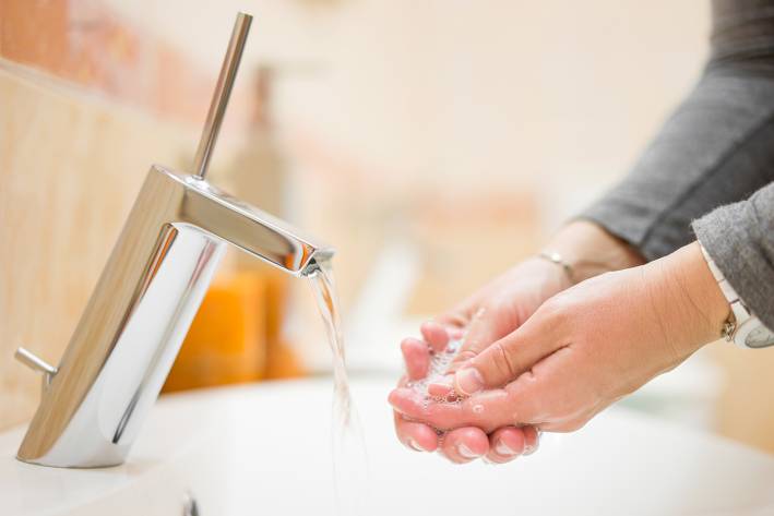a woman washing her hands with foaming soap