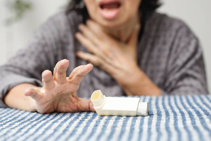 a woman reaching for her inhaler for breathing problems