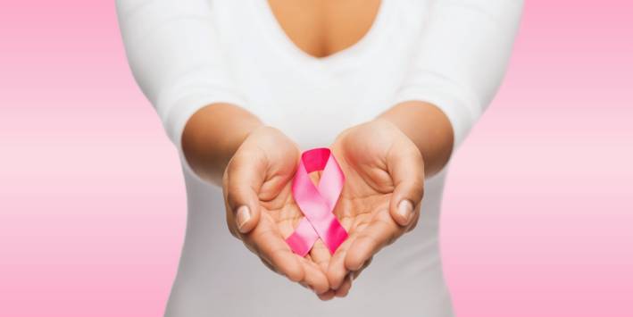 Woman holds breast cancer ribbon