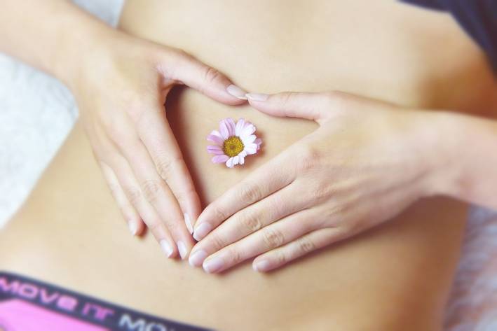 a young woman with a flower on her tummy
