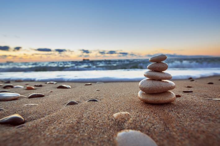 Stones balanced on a beach at sunrise