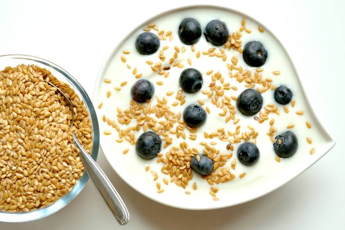 a bowl of yogurt with blueberries and flaxseed