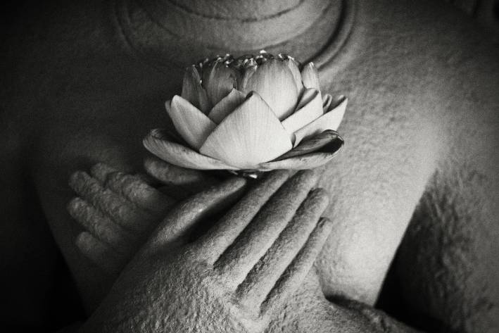 Buddha statue holding lotus flower.