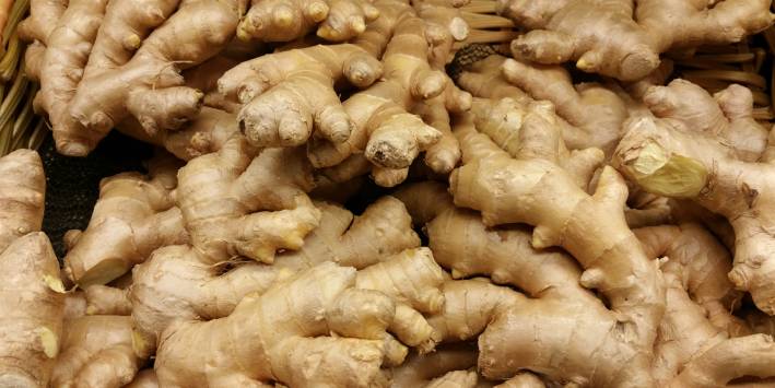 a platter of sliced and whole ginger root