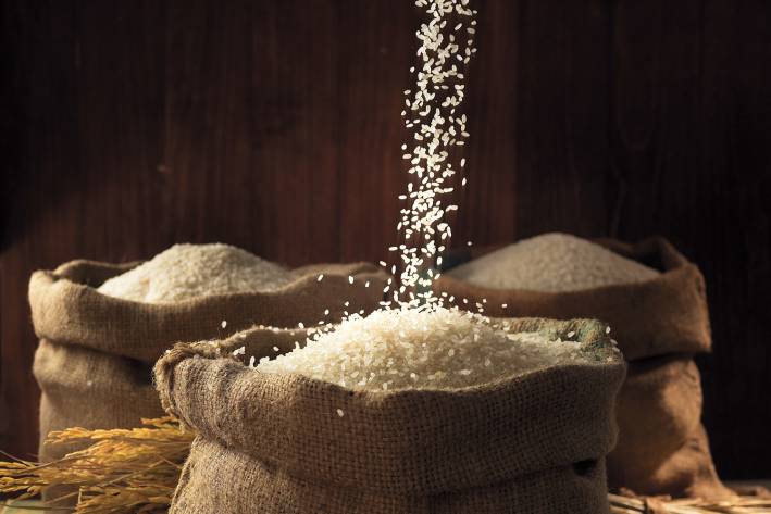 White rice being poured into burlap sacks