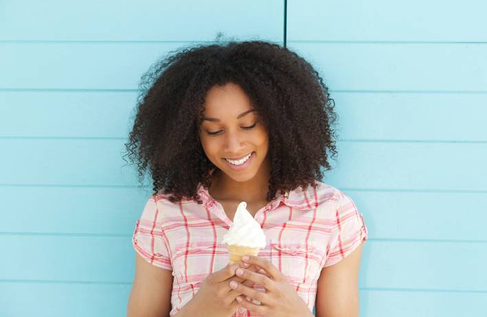 Woman smiling holding an ice cream cone.