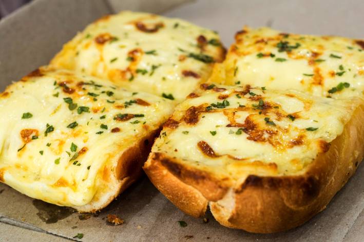 fresh cheesy garlic bread on a baking sheet