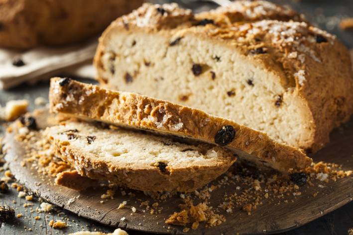 a freshly baked and sliced loaf of soda bread with raisins