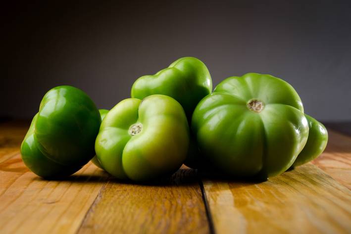 Green tomatoes on a wooden table