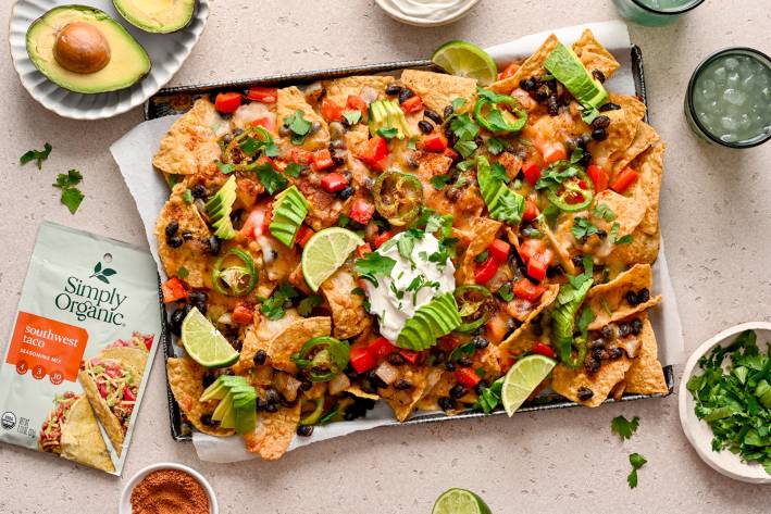 a large plate of tortilla chips with beans, cheese, and avocado