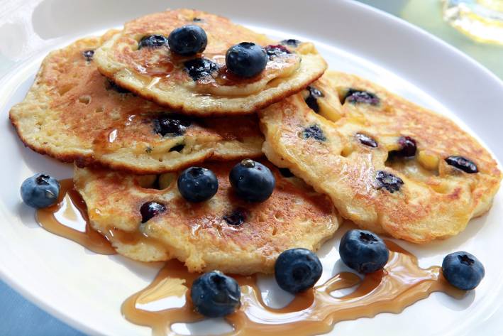 blueberry pancakes drizzled with maple syrup