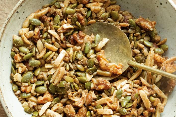 a bowl of granola, nuts, and seeds