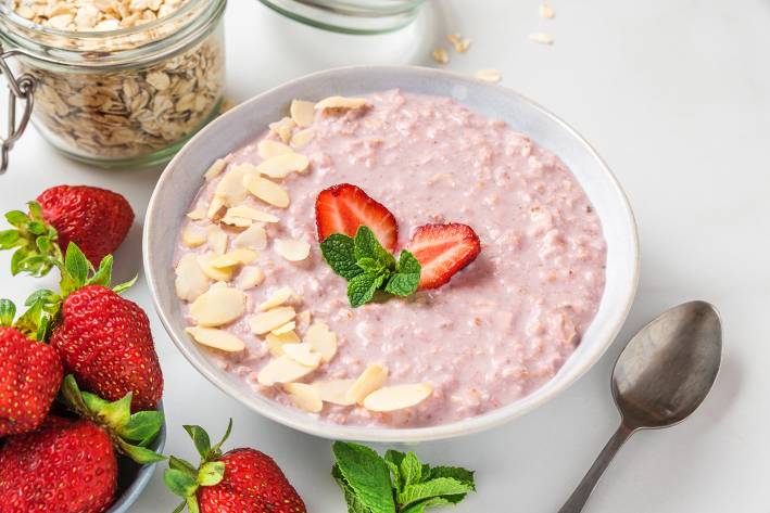 a bowl of strawberry oatmeal with almonds