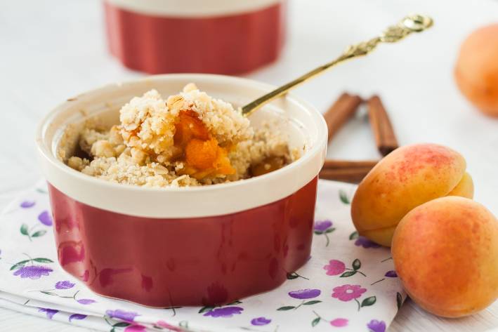 a dish full of apricot and broken-up oat crust