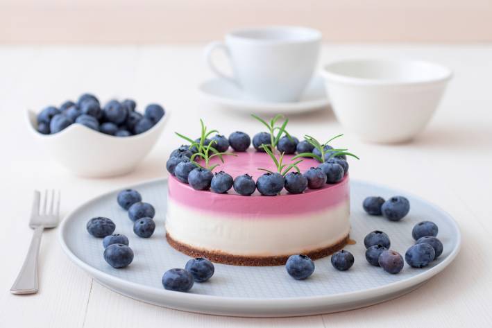 A blueberry cheesecake on a plate ready to serve.