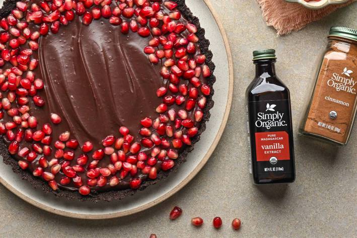 a no-bake tart covered in ganache and pomegranate arils