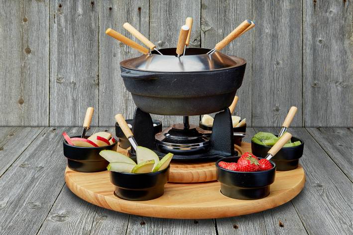 Fruit fondue on a plate on the background of wooden boards