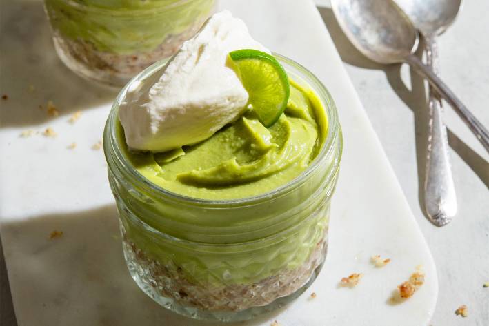 a small mason jar lined with nuts and filled with key lime pie filling