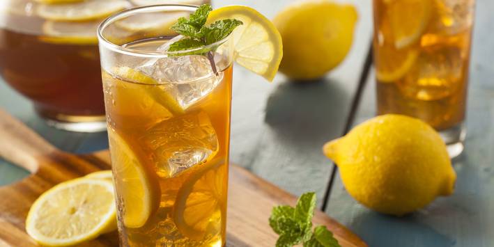 Freshly made iced tea in a glass with lemon.