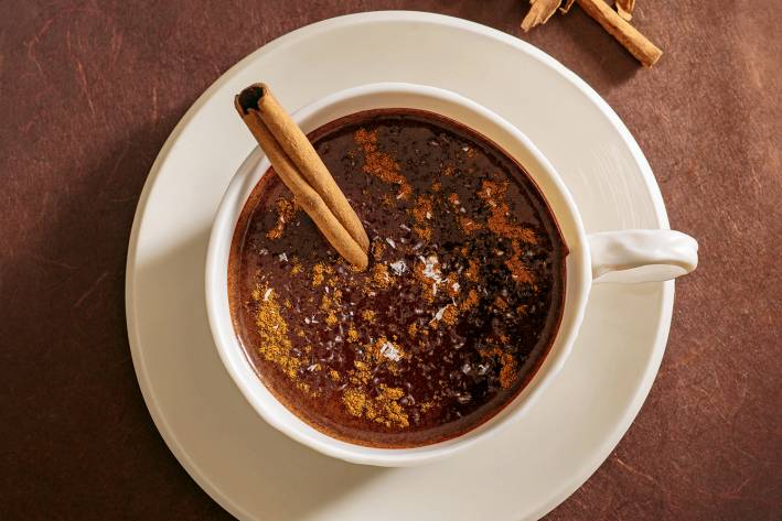 a mug of hot cocoa with a cinnamon stick