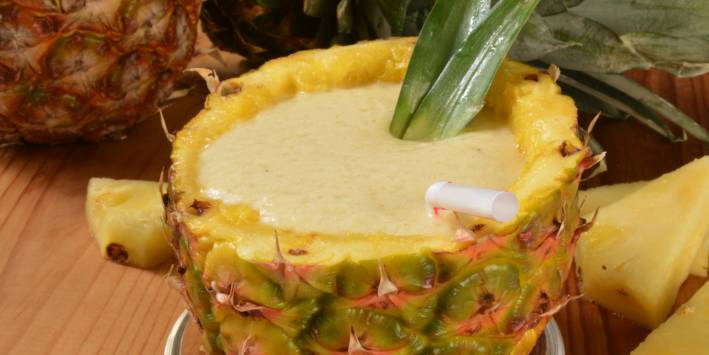 a smoothie served in a pineapple shell