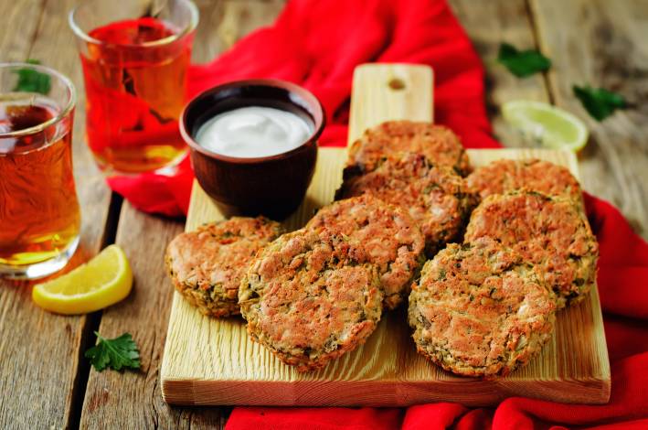 lentil and zucchini patties with a lemon and a cup of yogurt sauce