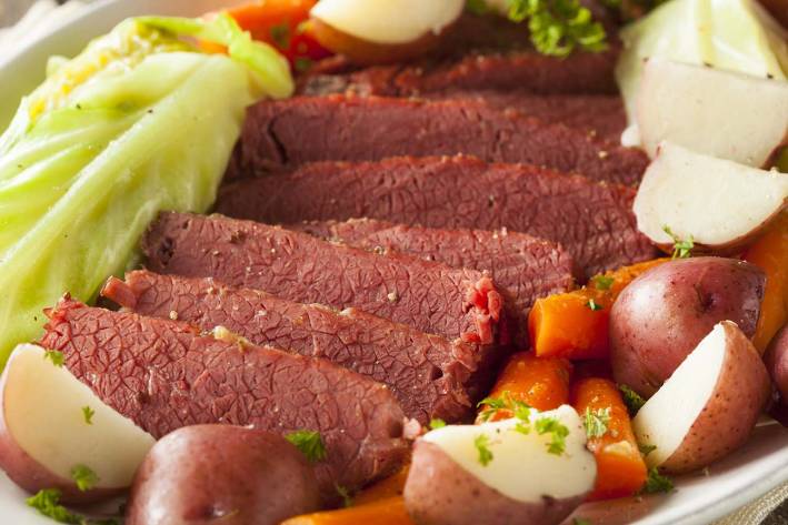 A plate of corned beef and cabbage with potatoes and carrots