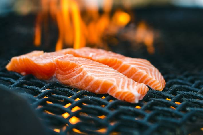 gorgeous salmon on a flaming charcoal grill