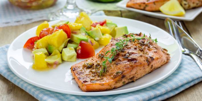 A plate of salmon with fruity avocado salsa