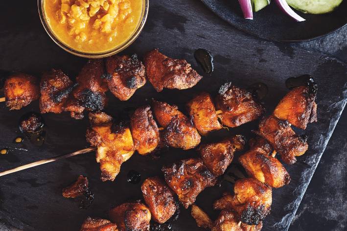 Chicken Satay skewers with a bowl of peanut dipping sauce on the side