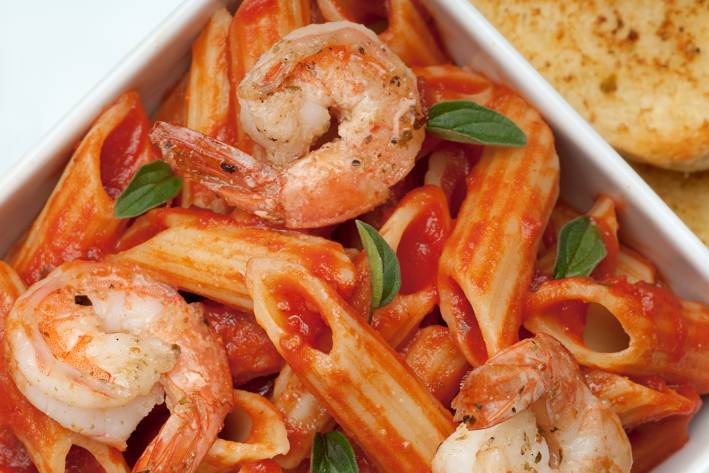 a bowl of penne and shrimp in red sauce