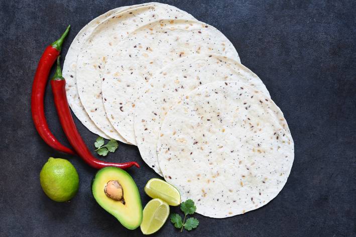 corn tortillas, sliced avocado, and chili peppers