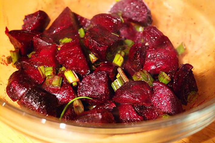 roasted beets mixed with scallions in a bowl