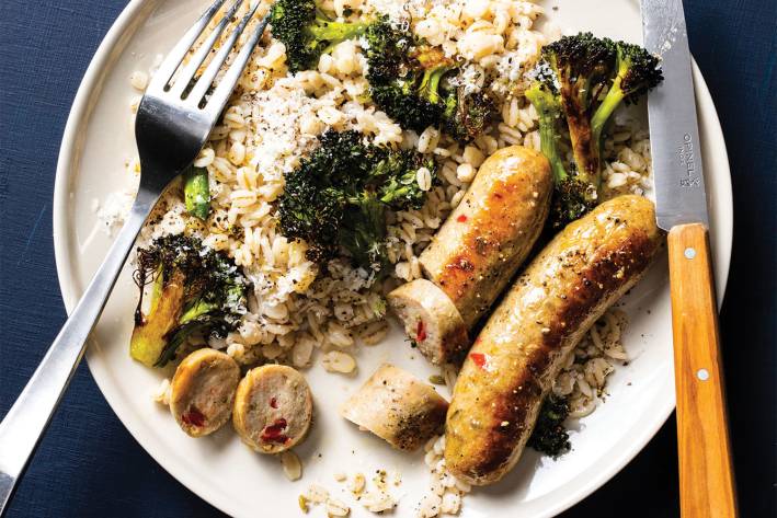 a plate of sausage, barley, and broccoli