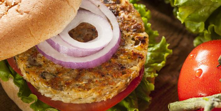 Veggie burger with onion, tomato and lettuce on wheat bun